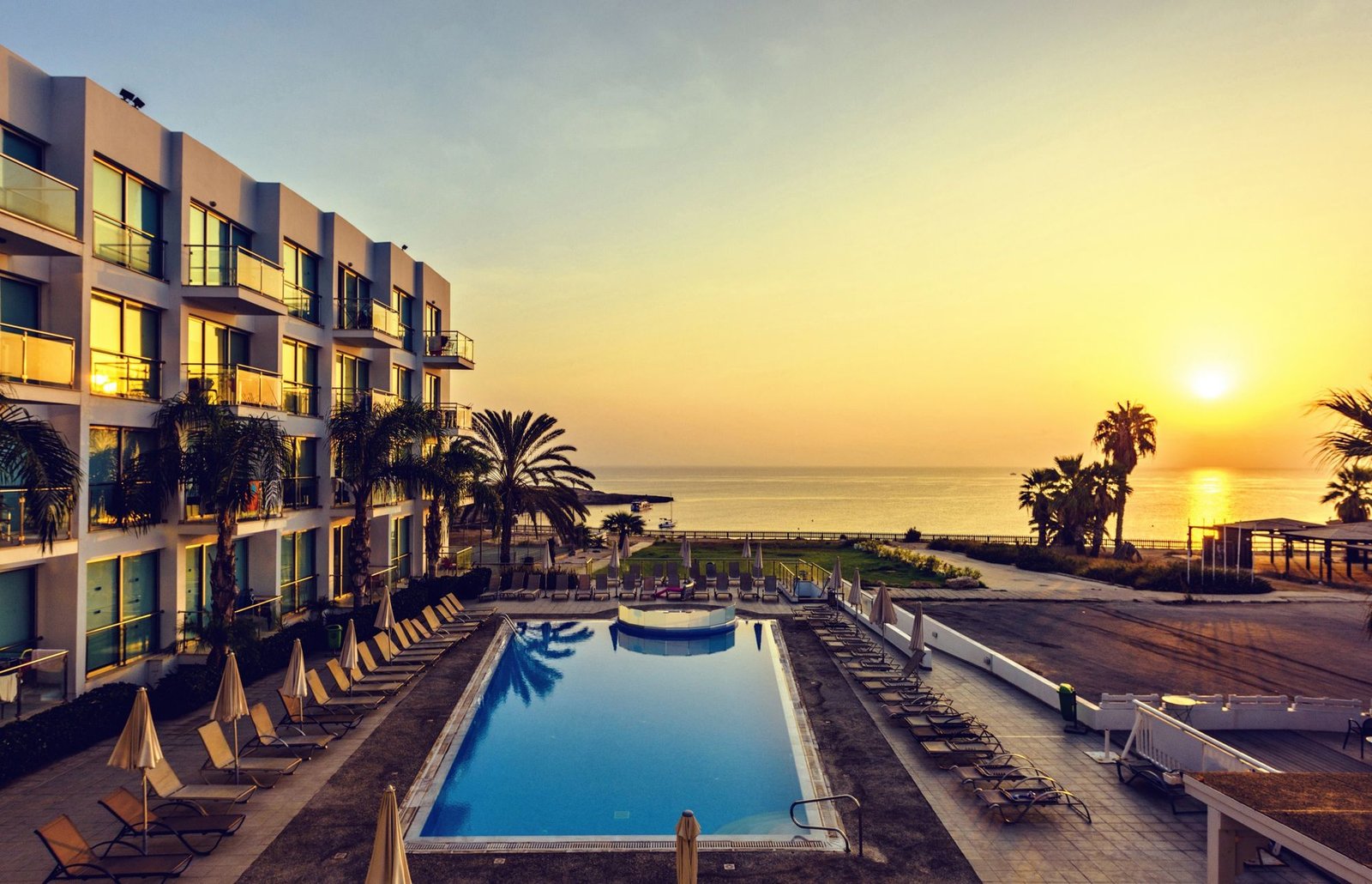 Resort pool and palms at sunset